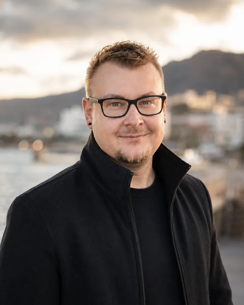 Porträt von Kevin Reymann, im Hintergrund eine Bucht im Abendlicht